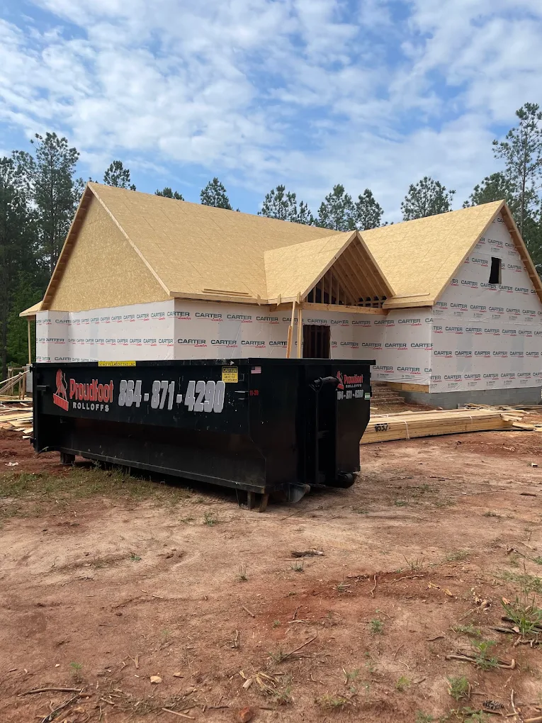 Proudfoot Rolloffs roll-off dumpster at a new home framing site near Greenwood, SC