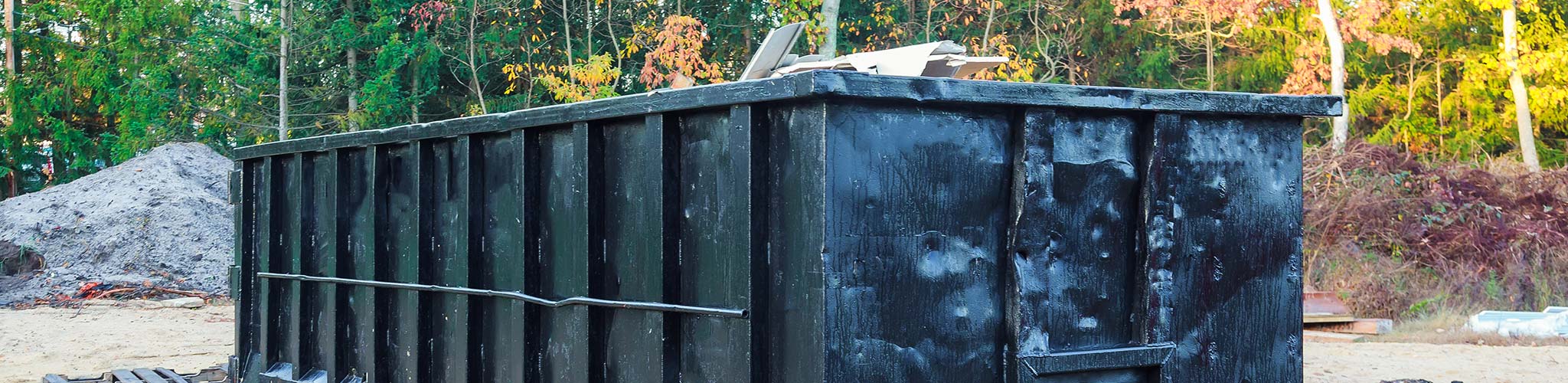 Proudfoot Rolloffs black roll-off dumpster set on a Greenwood, SC property