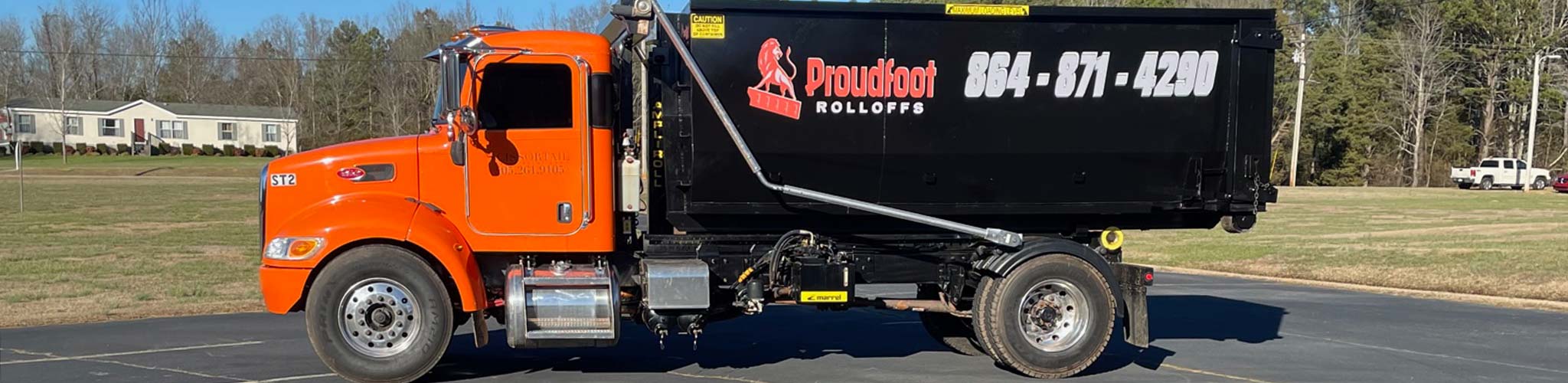 The Proudfoot Rolloffs orange Peterbilt roll-off truck