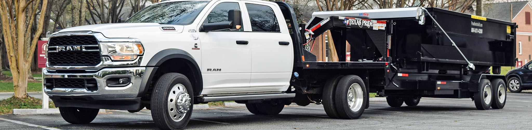Proudfoot Rolloffs truck delivering a black roll-off dumpster in Greenwood, SC