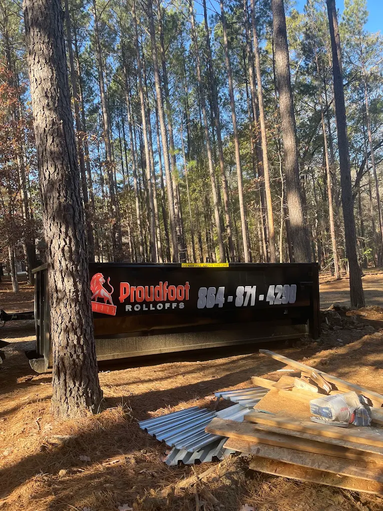 Proudfoot Rolloffs dumpster at a wooded job site in Abbeville County, SC