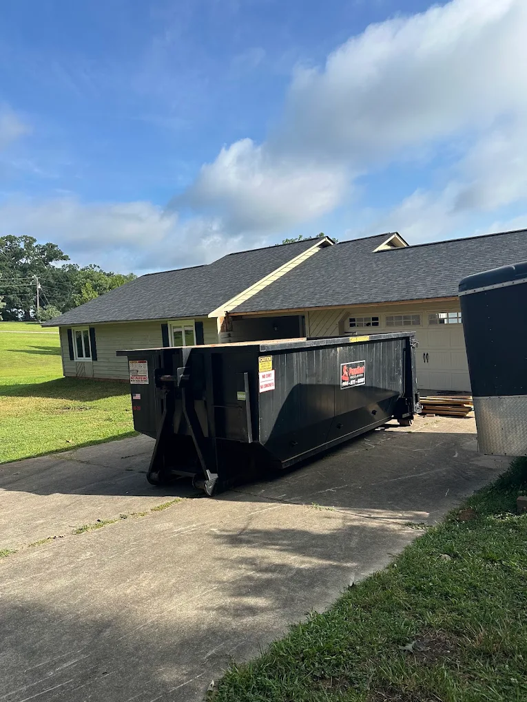 Proudfoot Rolloffs black roll-off dumpster on a residential driveway in Greenwood, SC