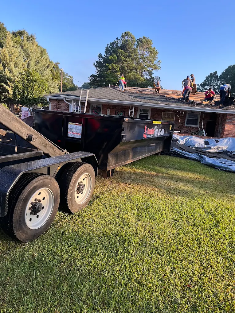 Roofing crew tearing off shingles into a Proudfoot Rolloffs dumpster in Greenwood, SC